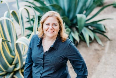 a photo of a woman in front of cactuses, taken from above